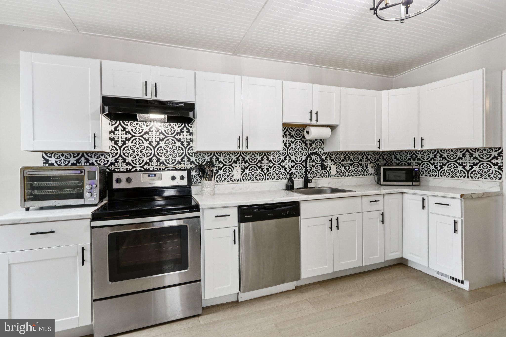 418 Walnut Street Pottstown, PA 19464 - Photo 6 of 52 a kitchen with granite countertop white cabinets and white appliances