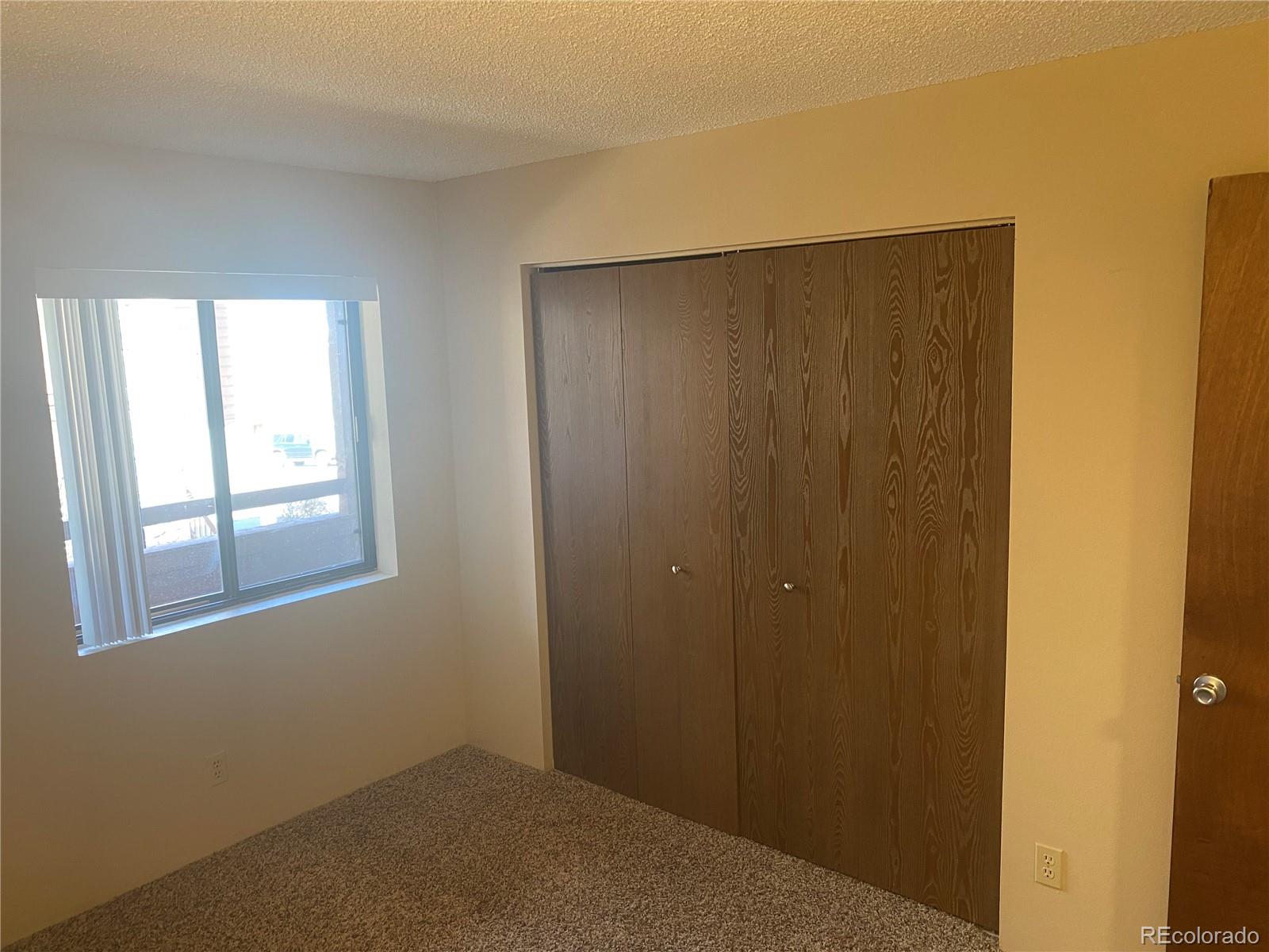 4671 South Decatur Street, Unit 232 Englewood, CO 80110 - Photo 16 of 32 a view of an empty room with windows and closet