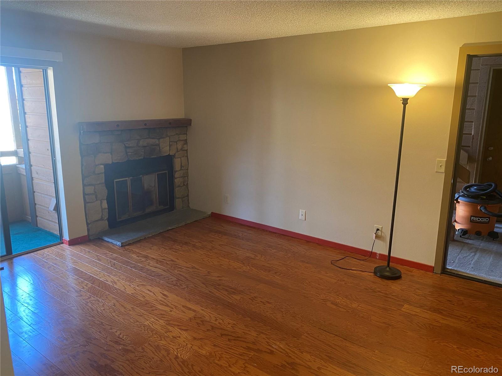4671 South Decatur Street, Unit 232 Englewood, CO 80110 - Photo 5 of 32 a view of an empty room with wooden floor and a fireplace