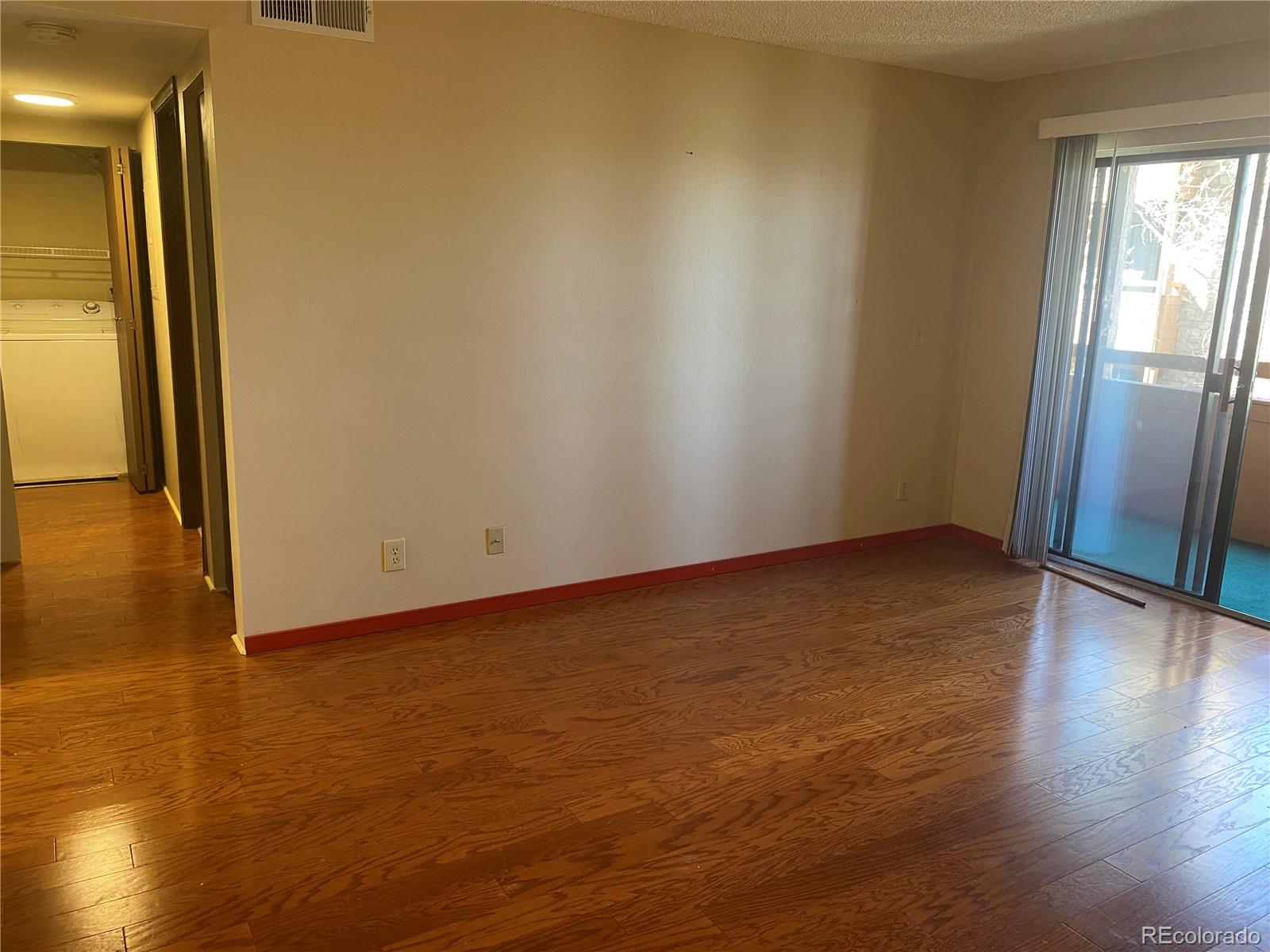 4671 South Decatur Street, Unit 232 Englewood, CO 80110 - Photo 6 of 32 a view of an empty room with wooden floor and a window