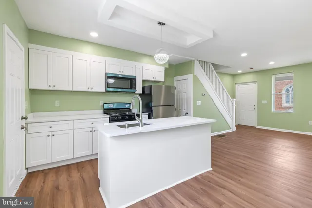 a kitchen with cabinets and wooden floor