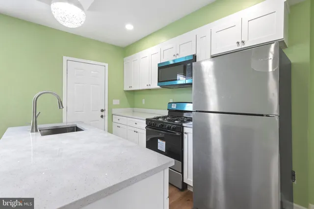 a kitchen with stainless steel appliances a refrigerator sink and stove