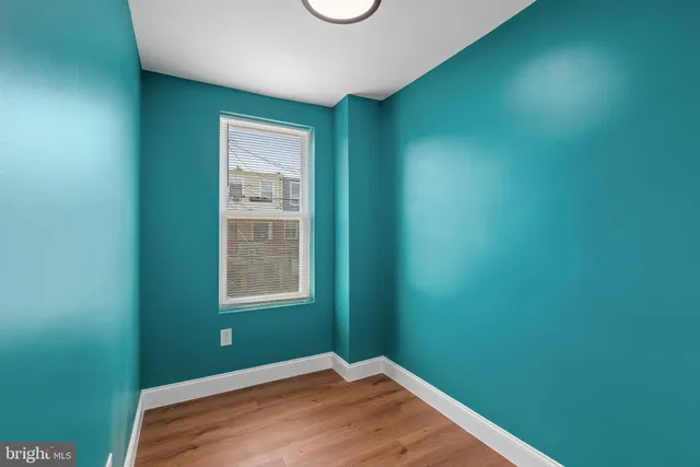 a view of an empty room with window and closet area