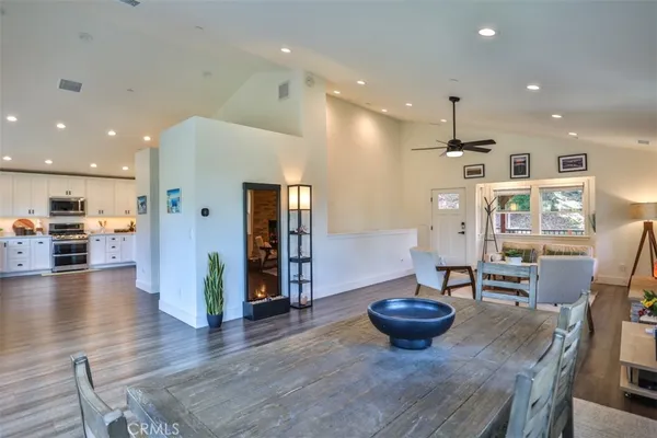 a view of a dining room with furniture a kitchen and chandelier