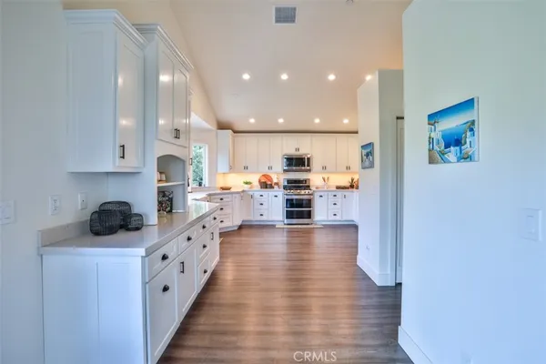 a kitchen with stainless steel appliances lots of counter top space cabinets and furniture