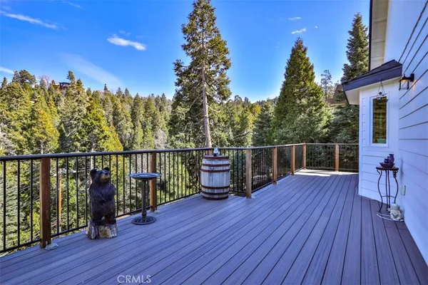 a view of a balcony with wooden floor and outdoor seating
