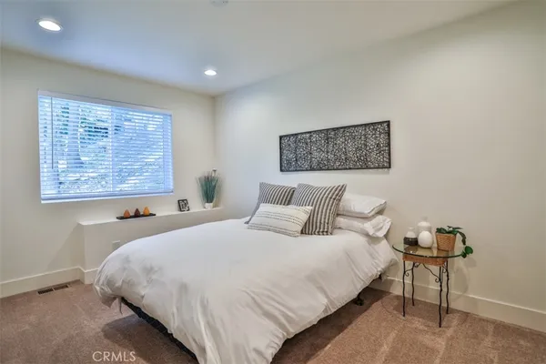 a bedroom with a bed and a painting on the wall