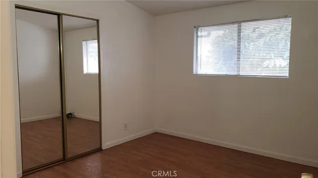 an empty room with wooden floor and a window
