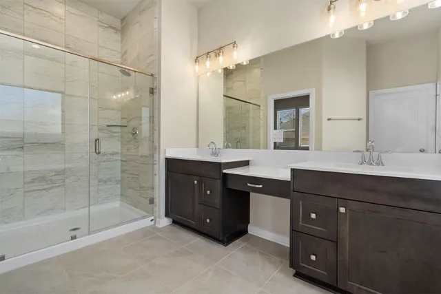 a bathroom with a sink double vanity and a shower