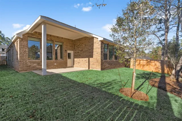 a view of a house with backyard and a tree