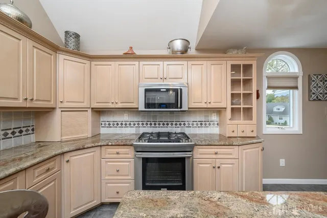 a kitchen with granite countertop a stove sink and cabinets