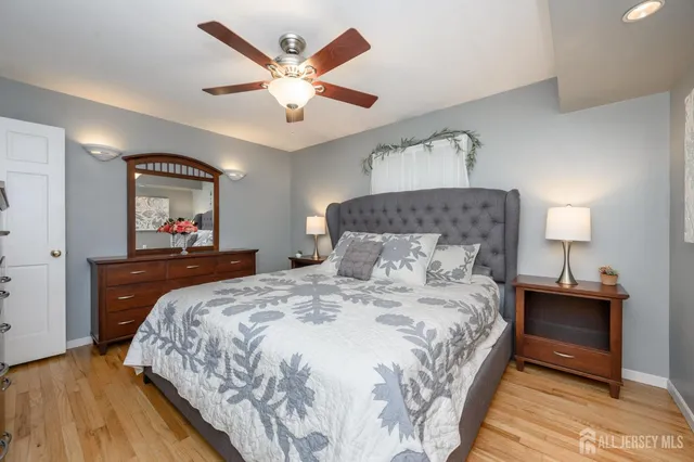 a bedroom with a bed and a lamp on dresser