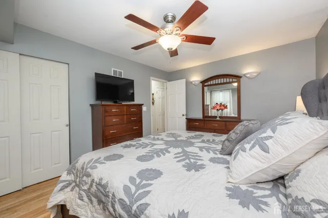 a bedroom with a bed a window and a flat screen tv