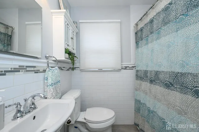 a bathroom with a sink a toilet and mirror