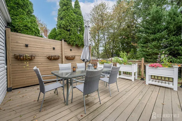 a view of a roof deck with table and chairs couches with wooden floor and fence