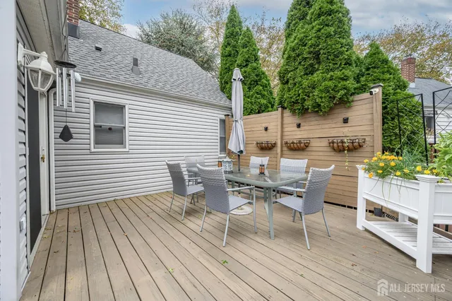a view of a roof deck with table and chairs with wooden floor and fence