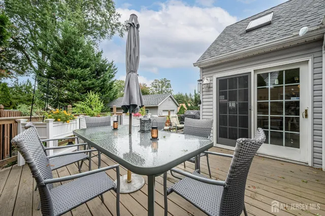 a roof deck with table and chairs and wooden floor