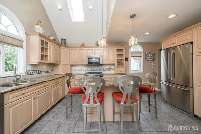 a kitchen with stainless steel appliances granite countertop a sink and refrigerator