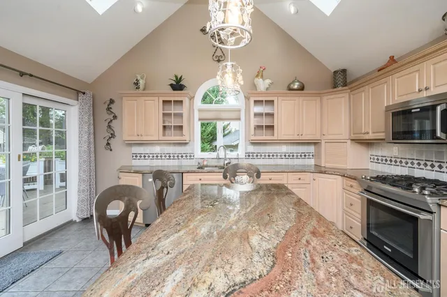 a kitchen with granite countertop a stove a sink and a refrigerator