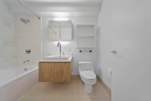 a bathroom with a toilet a sink a mirror and bathtub