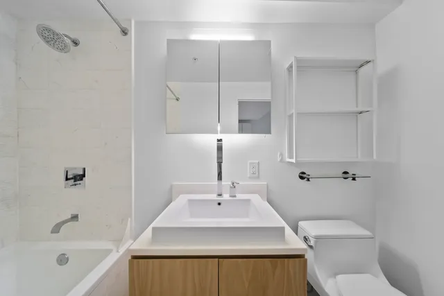 a bathroom with a sink a toilet and shower