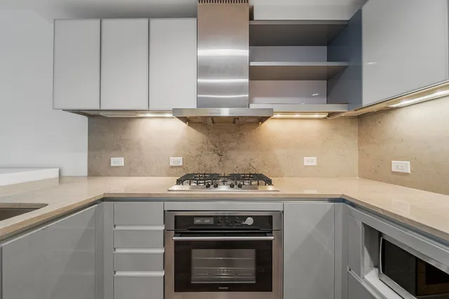 a stove top oven sitting inside of a kitchen