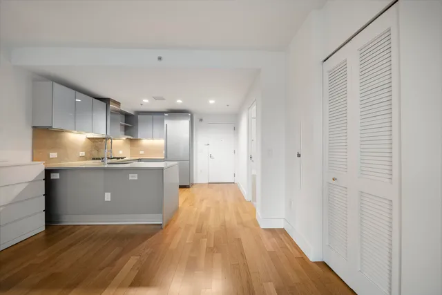 a kitchen with granite countertop white cabinets and stainless steel appliances