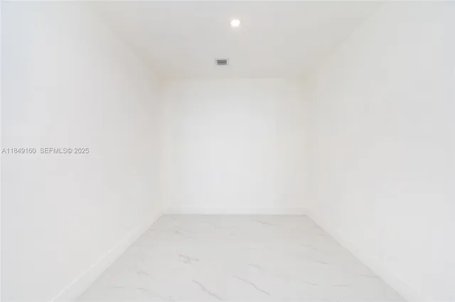 a view of a kitchen with fridge and wooden floor