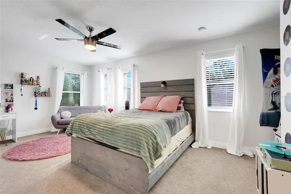 a bedroom with a bed a chandelier and a window