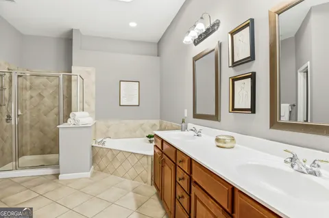 a bathroom with a double vanity sink a mirror and a bathtub