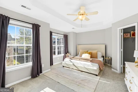 a bedroom with a large bed and a chandelier fan