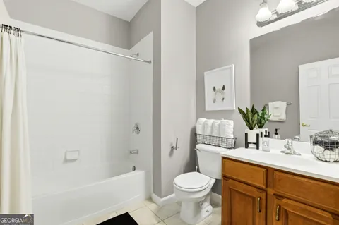 a bathroom with a granite countertop sink a toilet and shower