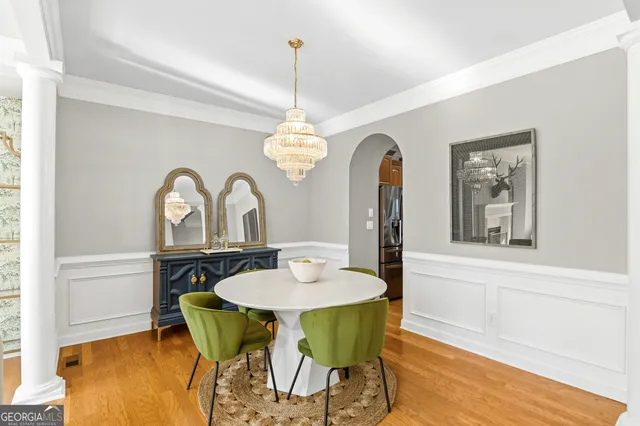 a dining room with furniture a chandelier and wooden floor