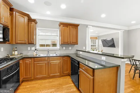 a kitchen with stainless steel appliances granite countertop a sink stove and cabinets
