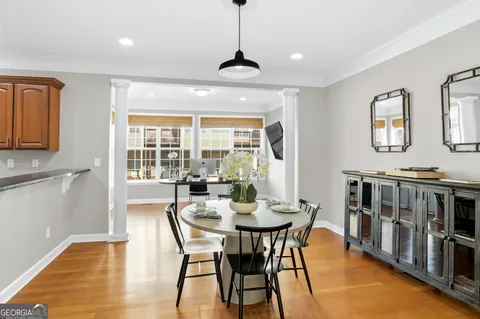 a dining room with furniture a chandelier and wooden floor