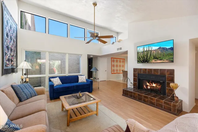 a living room with furniture a flat screen tv and a fireplace