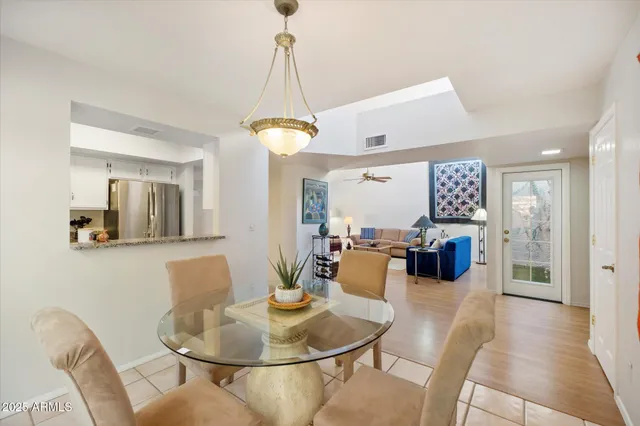 a living room with furniture a chandelier and a dining table