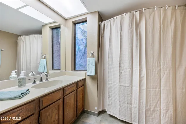 a bathroom with a granite countertop double vanity and a mirror
