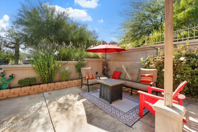 an outdoor sitting area with a couch and an umbrella