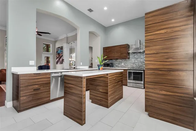 a kitchen with stainless steel appliances kitchen island granite countertop a sink and a large window