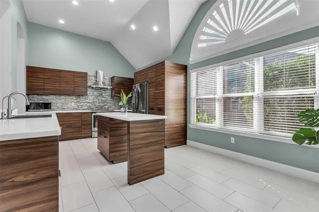 a kitchen with stainless steel appliances granite countertop a sink and a refrigerator