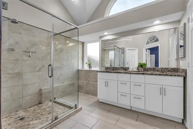 a bathroom with a shower and a sink a mirror