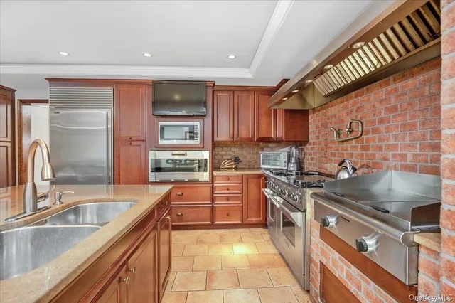 a kitchen with stainless steel appliances granite countertop a sink a stove and a refrigerator