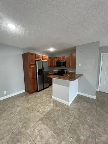 a kitchen with stainless steel appliances a refrigerator sink and microwave