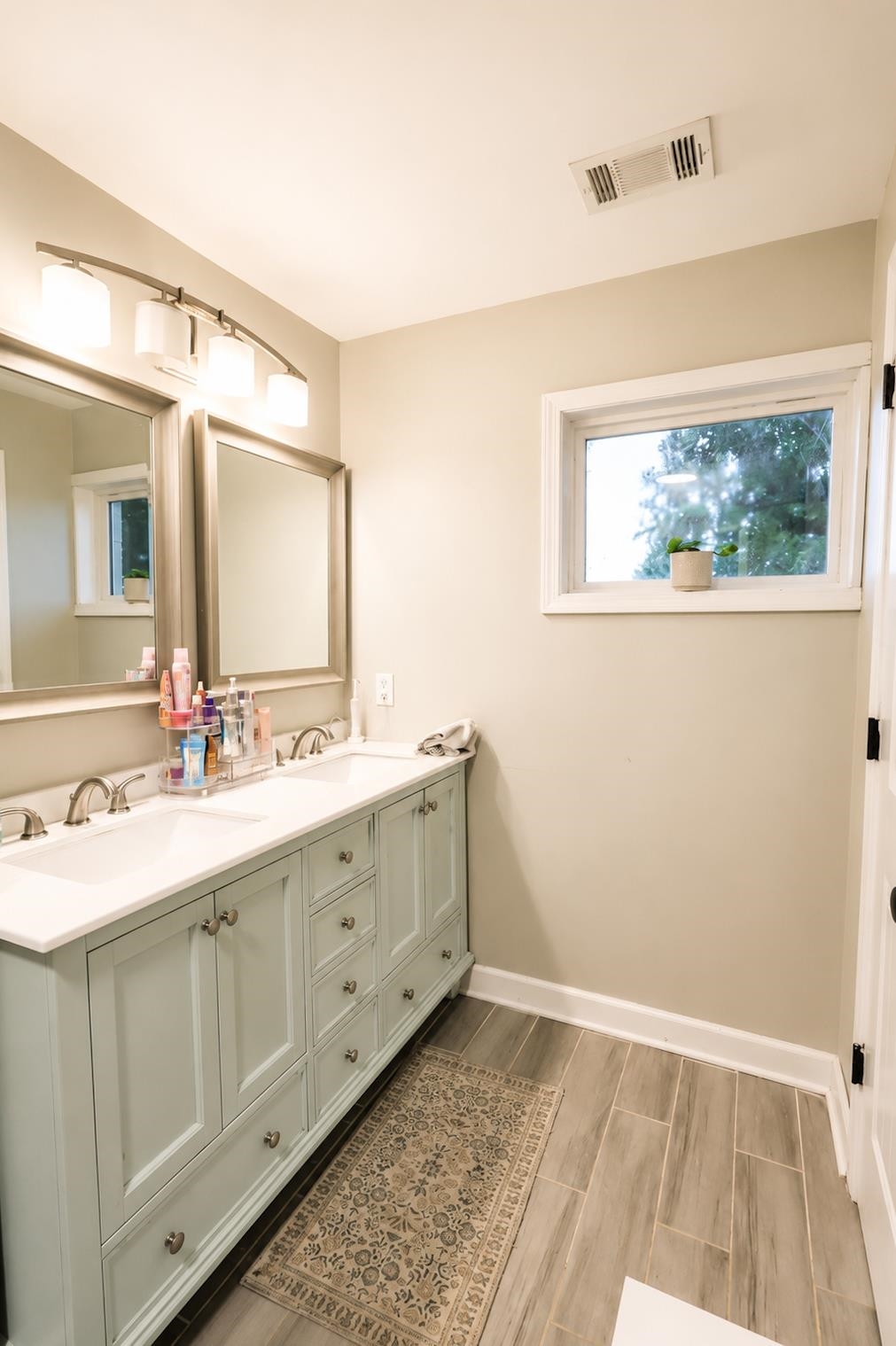 10093 Mt Carmel Road Brighton, TN 38011 - Photo 27 of 36 Dual vanity with light blue cabinetry, white countertops, and brushed nickel fixtures