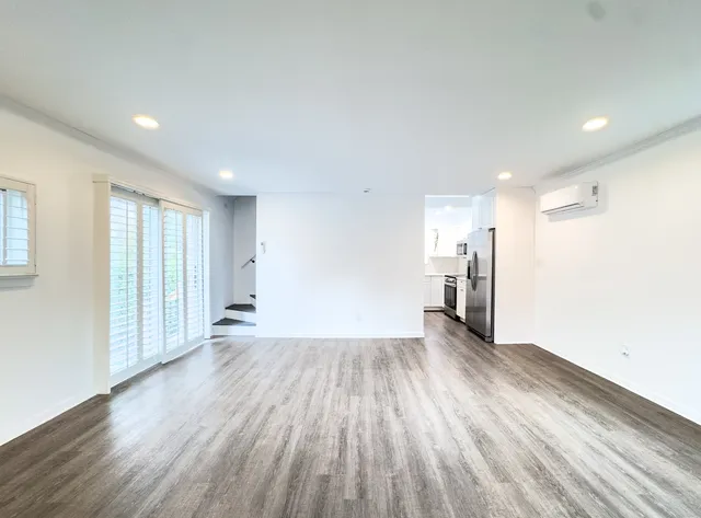 a view of a big room with wooden floor and windows