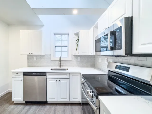 a kitchen with stainless steel appliances white cabinets and a sink