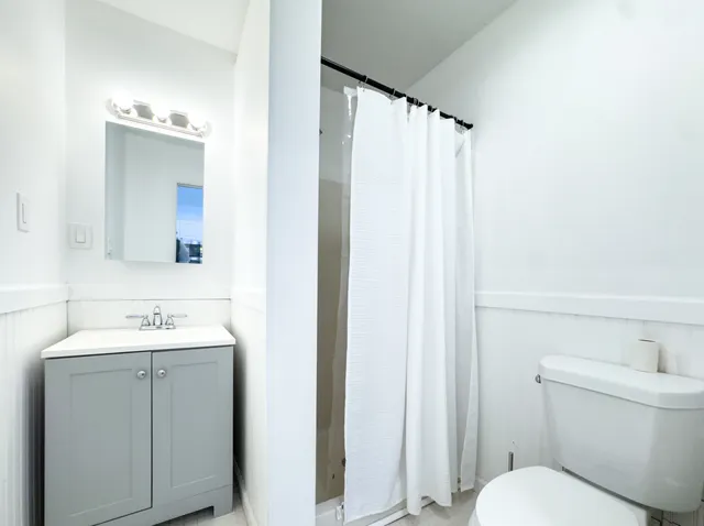 a bathroom with a sink a toilet and shower