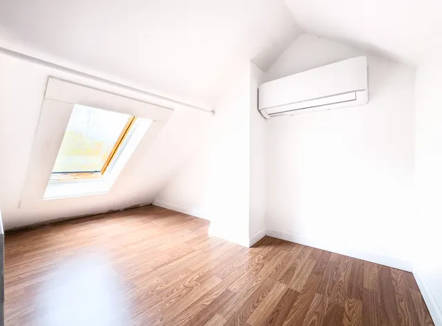 a view of a room with wooden floor and a window
