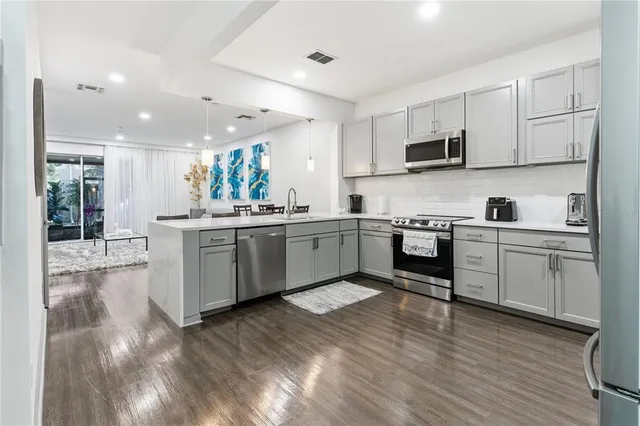 a kitchen with a sink cabinets and wooden floor